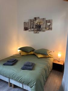 a bedroom with a large bed with two towels on it at Les toits d'Albatre in Dieppe