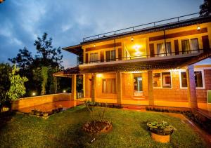 uma casa grande com um relvado em frente em Wild Courtyard Wayanad Resort em Wayanad