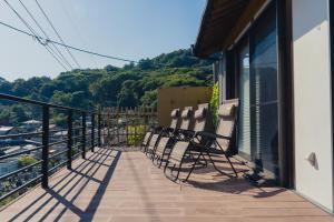 einen Balkon mit Stühlen auf einem Gebäude in der Unterkunft 合い宿 くまもと in Kumamoto