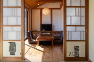 ein Wohnzimmer mit einem Tisch und einem TV in der Unterkunft 合い宿 くまもと in Kumamoto