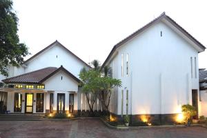 Una gran casa blanca con luces encendidas. en ARCS House Menteng by Jambuluwuk, en Yakarta