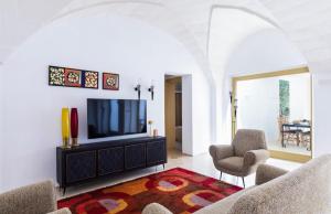 een woonkamer met een flatscreen-tv en stoelen bij Tenuta Fonte in Ostuni +14 foto's