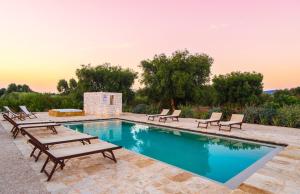 een zwembad met ligstoelen en een zwembad bij Tenuta Fonte in Ostuni
