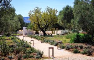 een tuin met een pad met banken en planten bij Tenuta Fonte in Ostuni