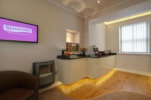 a living room with a tv on the wall at Farnham Hotel in Tenby