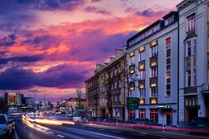 eine Stadtstraße mit Gebäuden und einem wolkigen Himmel in der Dämmerung in der Unterkunft Kamienica Boutique ApartHotel in Białystok