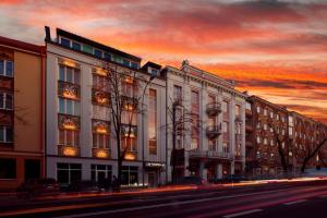 eine Stadtstraße mit Gebäuden und einem Sonnenuntergang in der Unterkunft Kamienica Boutique ApartHotel in Białystok