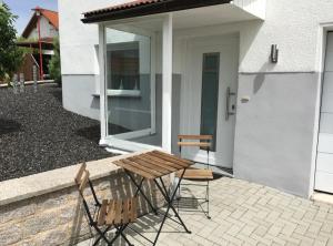 a picnic table and two chairs in front of a house at Ruhige Ferienwohnung in Heskem - Berthold Apartments in Heskem