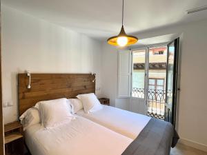 a bedroom with a large white bed and a window at 7 Kale Bed and Breakfast in Bilbao