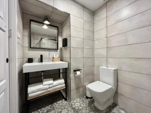 a bathroom with a toilet and a sink and a mirror at 7 Kale Bed and Breakfast in Bilbao