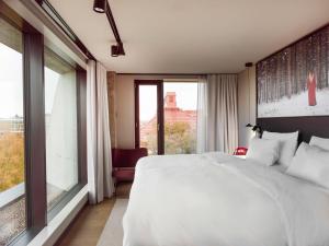 a bedroom with a white bed and a large window at Radisson RED Helsinki in Helsinki