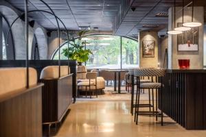 赫爾辛基的住宿－Radisson RED Helsinki，餐厅设有酒吧,配有桌椅