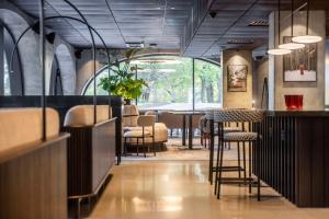 a restaurant with a bar with chairs and tables at Radisson RED Helsinki in Helsinki