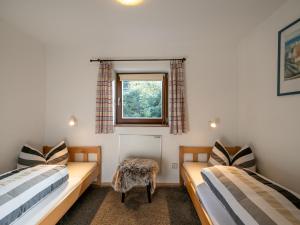 2 camas en una habitación con ventana en Chalet Kitzalm, en Oberndorf in Tirol