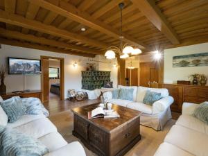 a living room with white couches and a table at Chalet Kitzalm in Oberndorf in Tirol