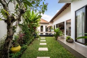 a garden path leading to a house with plants at Villa Jami by BaliSuperHost in Seminyak