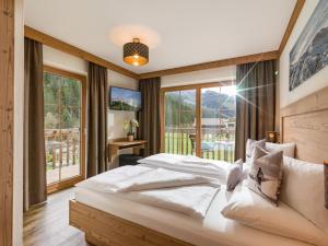 a bedroom with a large bed and a large window at Appart Bergleben-Deluxe **** in Gerlos