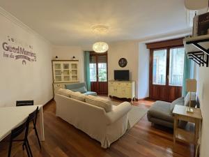 a living room with a white couch and a tv at 7 Kale Bed and Breakfast in Bilbao