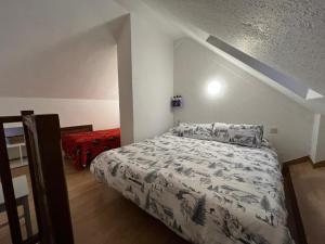 a bedroom with a bed with a white comforter at Apartamento esqui montaña Cofiñal in Cofiñal