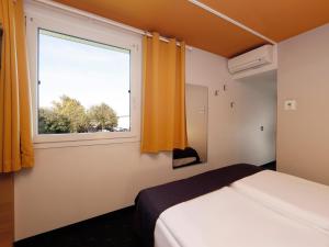 a bedroom with a bed and a window at B&B Hotel Berlin-Süd Genshagen in Ludwigsfelde