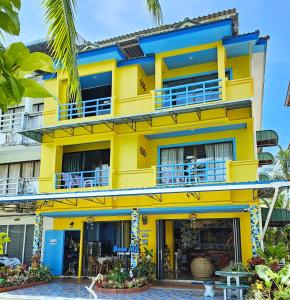 a yellow building with blue balconies at Lanta MP Place in Ko Lanta