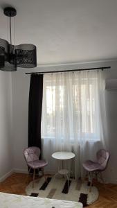 a room with two chairs and a table and a window at Studio Central Doamnei in Bucharest