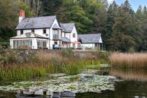 a house with lily pads in front of a pond at Lake House in Brecon