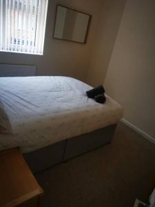 a bedroom with a bed with a black object on it at Darlington central 3 bed home in Darlington