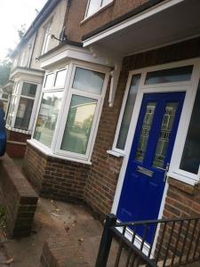 a brick house with a blue door and windows at Darlington central 3 bed home in Darlington