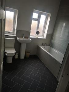 uma casa de banho com uma banheira, um WC e um lavatório. em Darlington central 3 bed home em Darlington