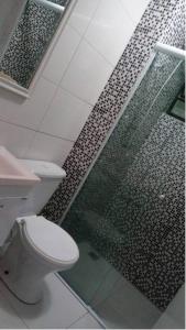een badkamer met een toilet en een glazen douche bij LA05-Bertioga, Próximo ao SESC, Riviera, Vista Linda, Indaiá in Bertioga