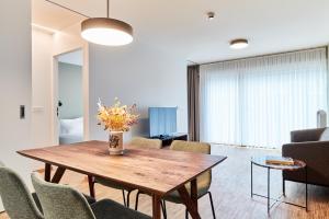 - un salon avec une table et des chaises en bois dans l'établissement Résidence du Lys - Perrin Apartments, à Luxembourg