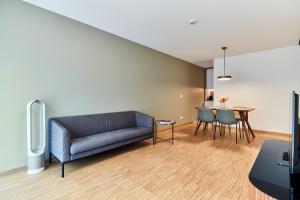 a living room with a couch and a table at Résidence du Lys - Perrin Apartments in Luxembourg