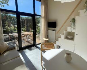 a living room with a table and a large window at Camping de Vinkenkamp in Lieren