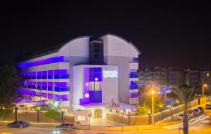 a large building with a purple door at night at Blue Wave Suite Hotel in Alanya