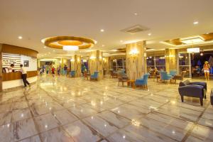 a lobby with chairs and tables in a building at Blue Wave Suite Hotel in Alanya