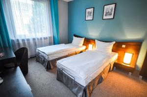 a hotel room with two beds and a window at Hotel Trzy Światy Spa & Wellness Rajska WySpa in Gliwice