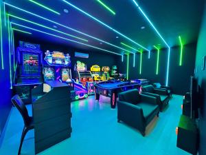 a gaming room with neon lights and video games at Blue Wave Suite Hotel in Alanya