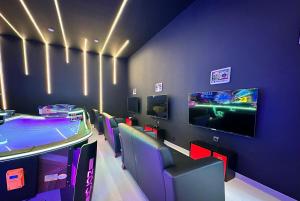 a gaming room with a table and chairs and a tv at Blue Wave Suite Hotel in Alanya