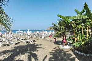 a beach with chairs and umbrellas and the ocean at Blue Wave Suite Hotel in Alanya +38 photos