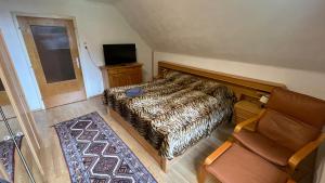 - une chambre avec un lit, une chaise et une télévision dans l'établissement Ferienhaus Martinz, 