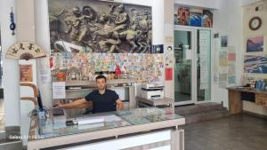 a man standing behind a counter in a store at Nicea Hotel in Selcuk