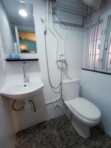 Baño blanco con aseo y lavamanos en Tempo Inn@ David Mansion, en Hong Kong