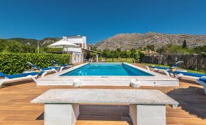 a swimming pool with a bench and chairs around it at Villa ANGELS in Pollença
