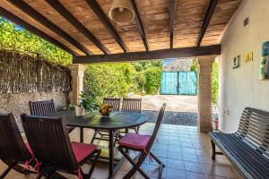 a table and chairs on a patio with a wooden ceiling at Villa ANGELS in Pollença