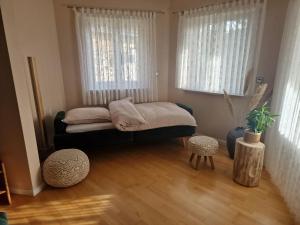 een bed in een kamer met 2 ramen bij Ferienwohnung Halbig in Absberg