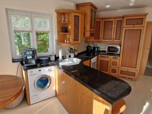 a kitchen with a sink and a washing machine at Ferienwohnung Halbig in Absberg