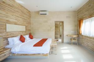 - une chambre avec un lit et un mur en bois dans l'établissement Agaru Villa Uluwatu by The Lavana, à Uluwatu