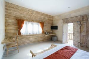Schlafzimmer mit Holzwänden, einem Bett und einem Fenster in der Unterkunft Agaru Villa Uluwatu by The Lavana in Uluwatu
