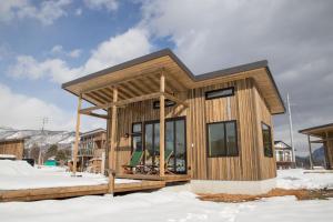 una pequeña casa de madera en la nieve en And MOUNTAIN en Hakuba